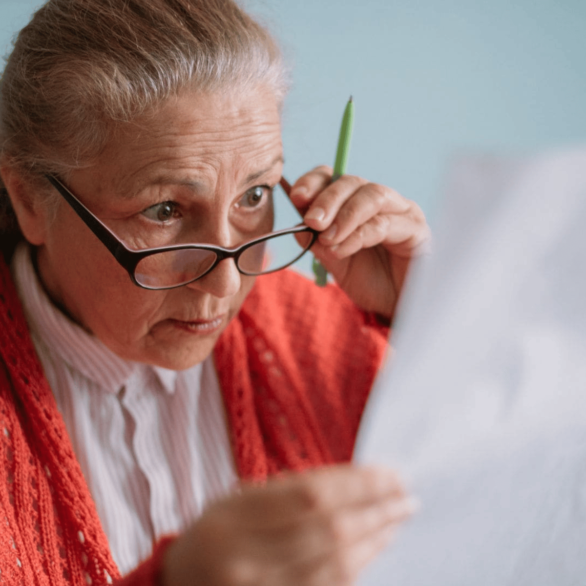 Mujer mayor revisando documentos con atención